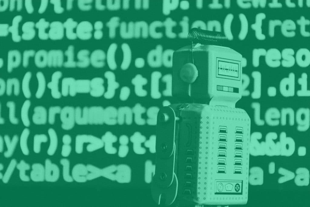 A robot toy stands in front of a wall of code