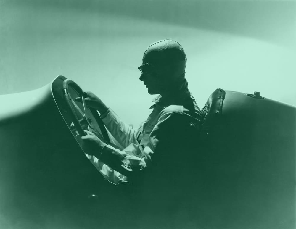 A moodily lit image of a race car driver