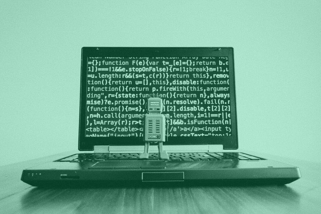 A vintage robot looks at a computer screen covered in code